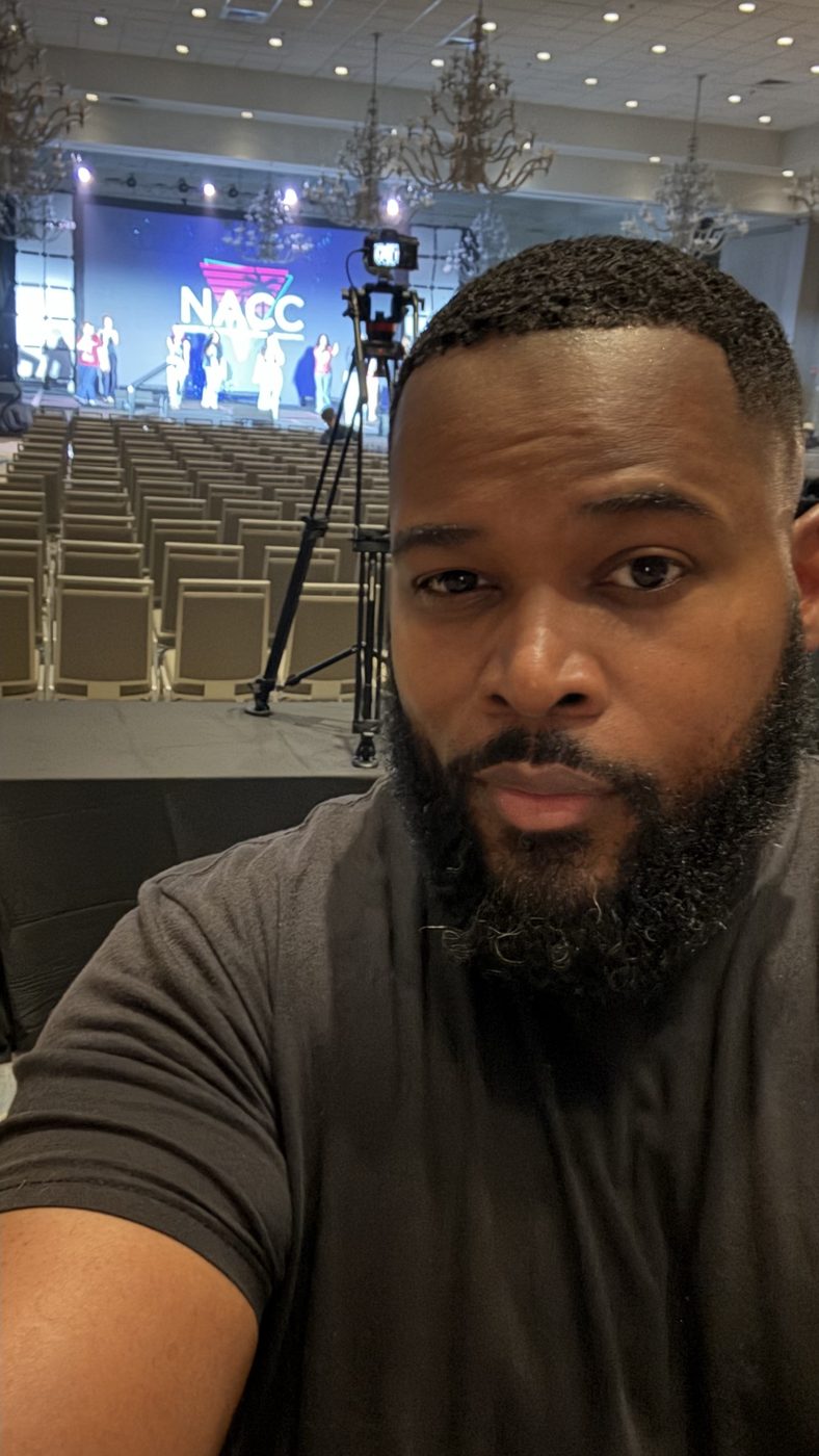 Fuljens Henry at the production position, camera and lit NACC stage behind him.